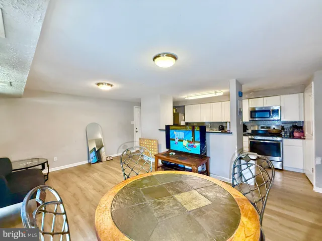 a view of a kitchen with kitchen island a dining table and chairs