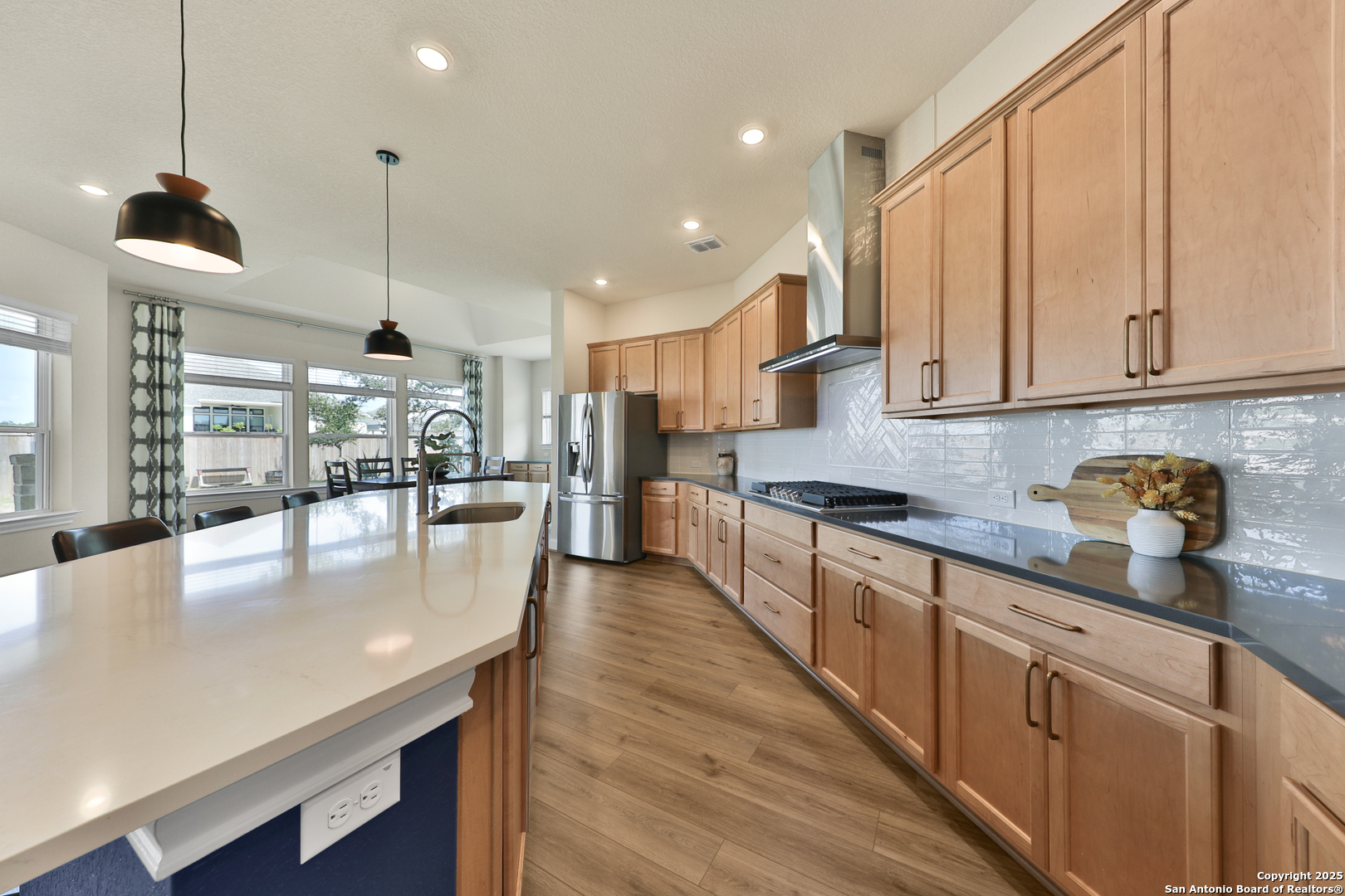 195 Piper Street Castroville, TX 78009 - Photo 13 of 47 a kitchen with stainless steel appliances granite countertop a stove refrigerator a oven and white cabinets with wooden floor