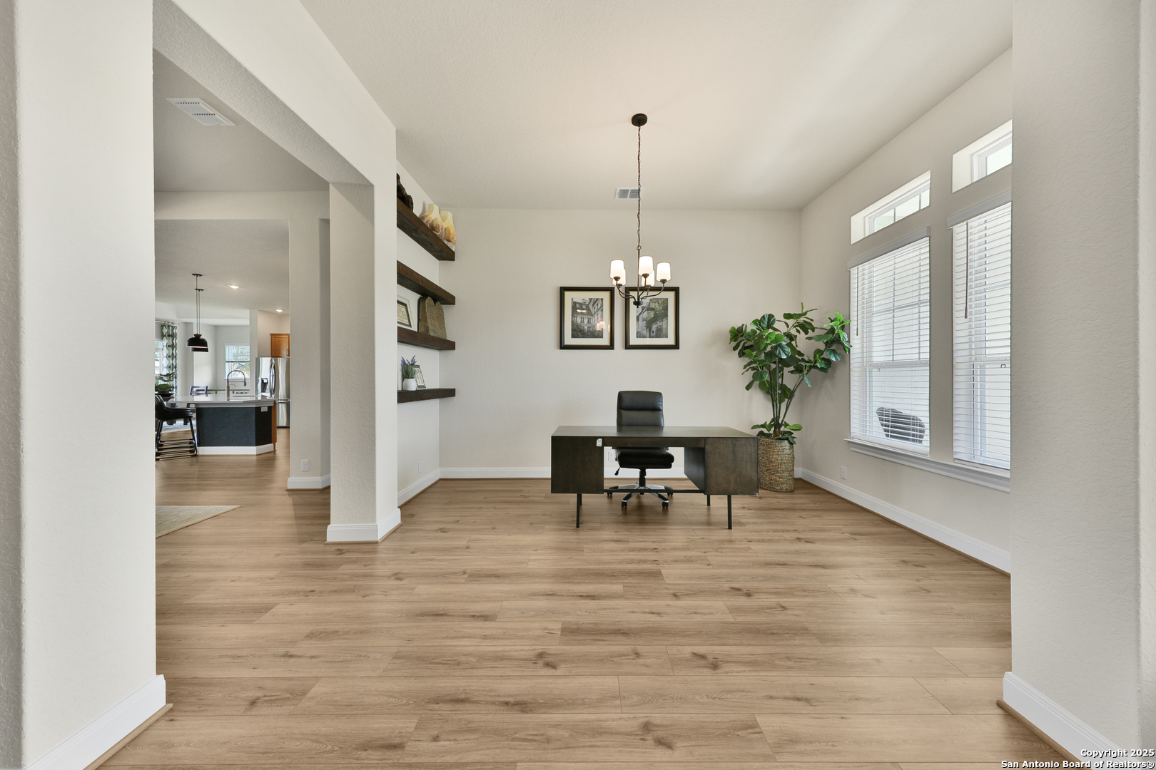 195 Piper Street Castroville, TX 78009 - Photo 6 of 47 a view of a livingroom with a dinning area hardwood floor and a chandelier