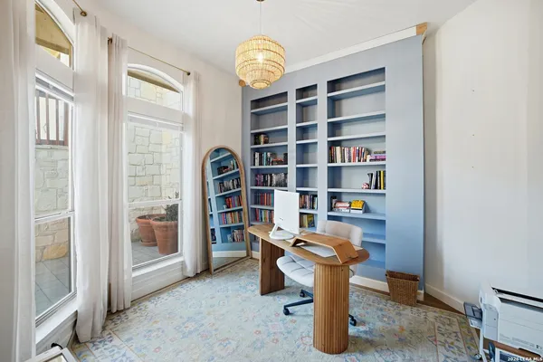 a view of a livingroom with workspace and a window