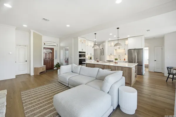 a living room with furniture and a dining table with wooden floor