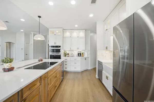 a large kitchen with kitchen island a large counter top space a sink stainless steel appliances and cabinets