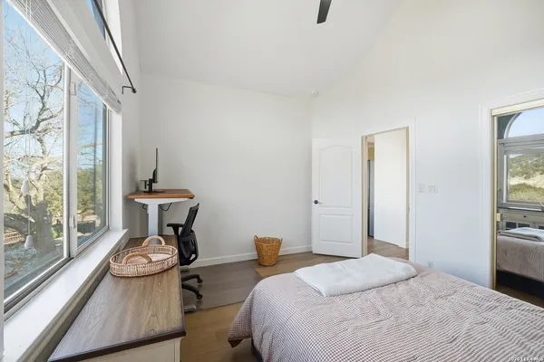 a bedroom with a bed and a large window with outer view