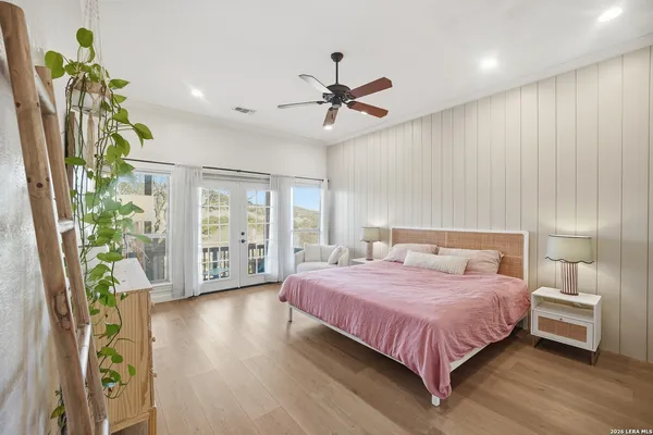 a bedroom with a bed chandelier and a window