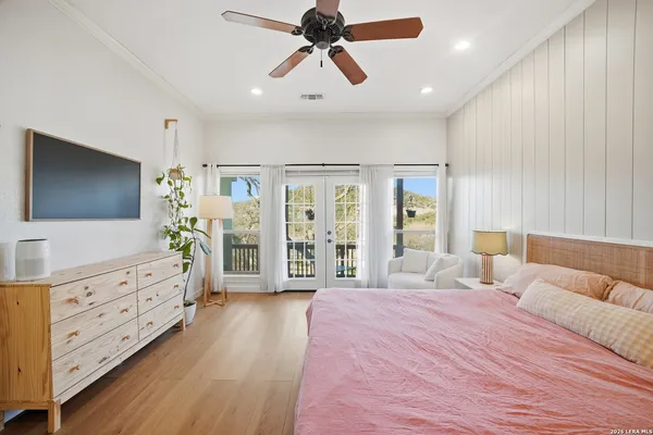 a spacious bedroom with a large bed and a flat tv screen on dresser