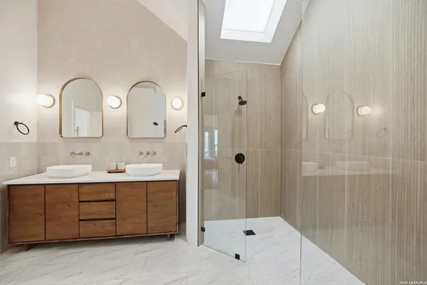 a bathroom with a double vanity sink mirror and shower