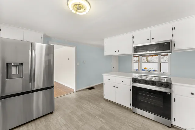 a kitchen with stainless steel appliances white cabinets and a refrigerator