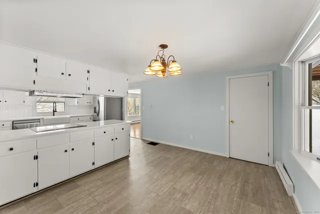 a kitchen with granite countertop white cabinets and a chandelier