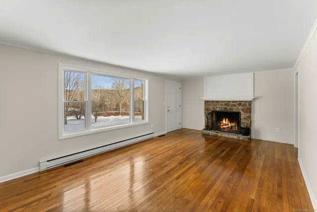 a view of an empty room with a fireplace and a window