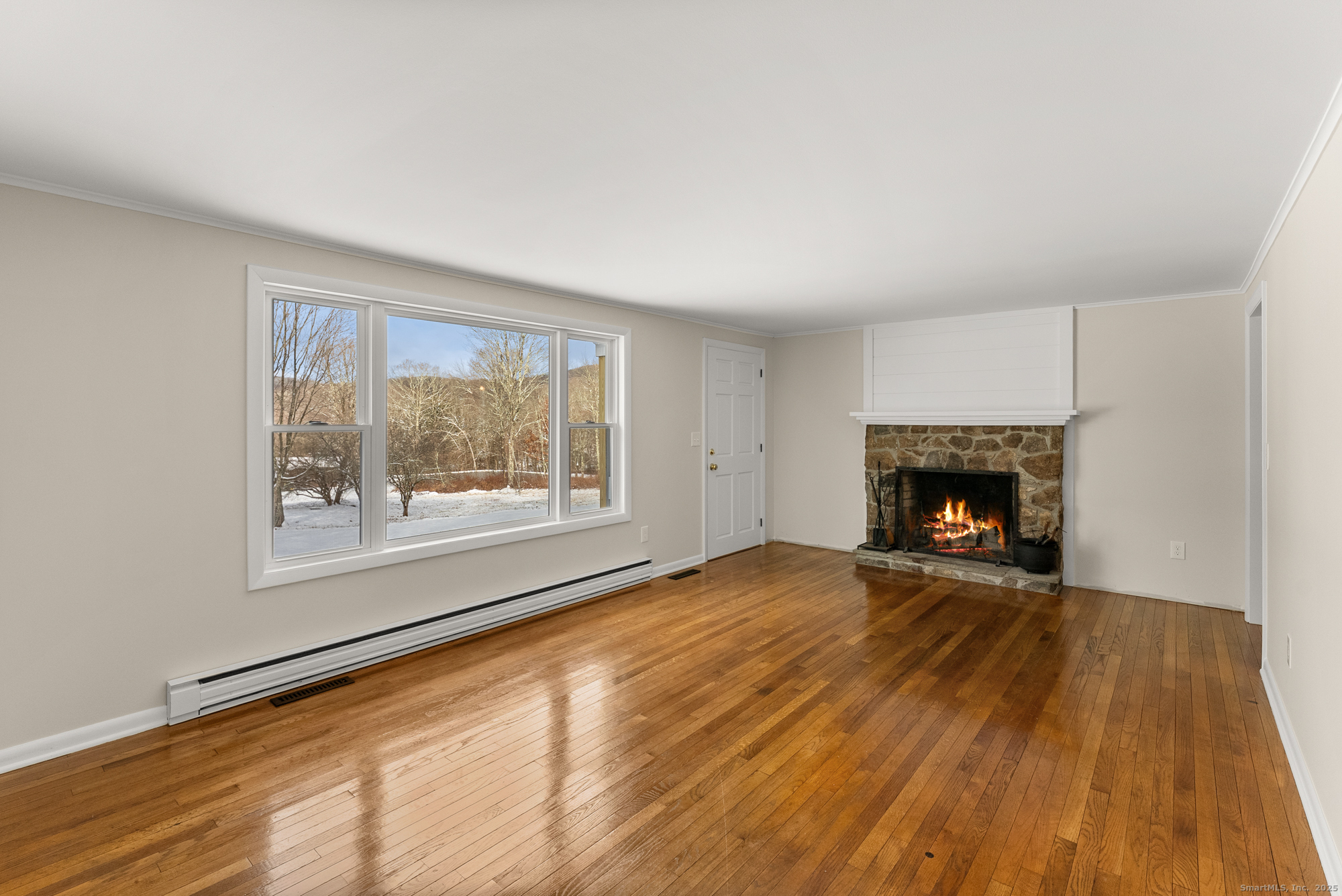 52 B Fuller Mountain Road Kent, CT 06757 - Photo 17 of 25 a view of an empty room with a fireplace and a window
