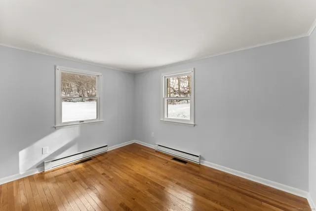 a view of a room with wooden floor and window