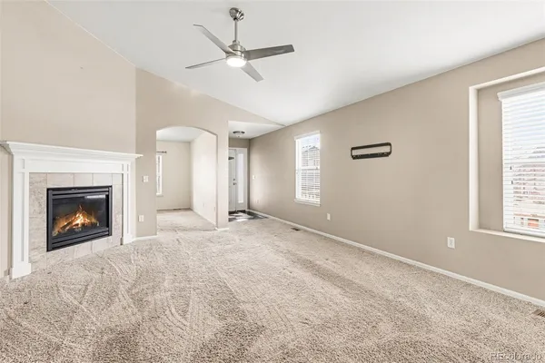 a view of an empty room with window and fireplace