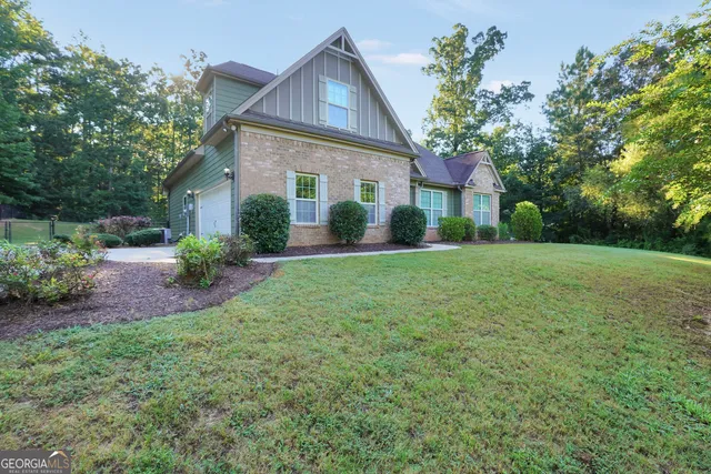a front view of a house with a yard and trees