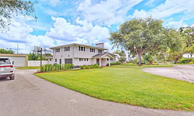 a view of a house with garden and a cars park side of the road