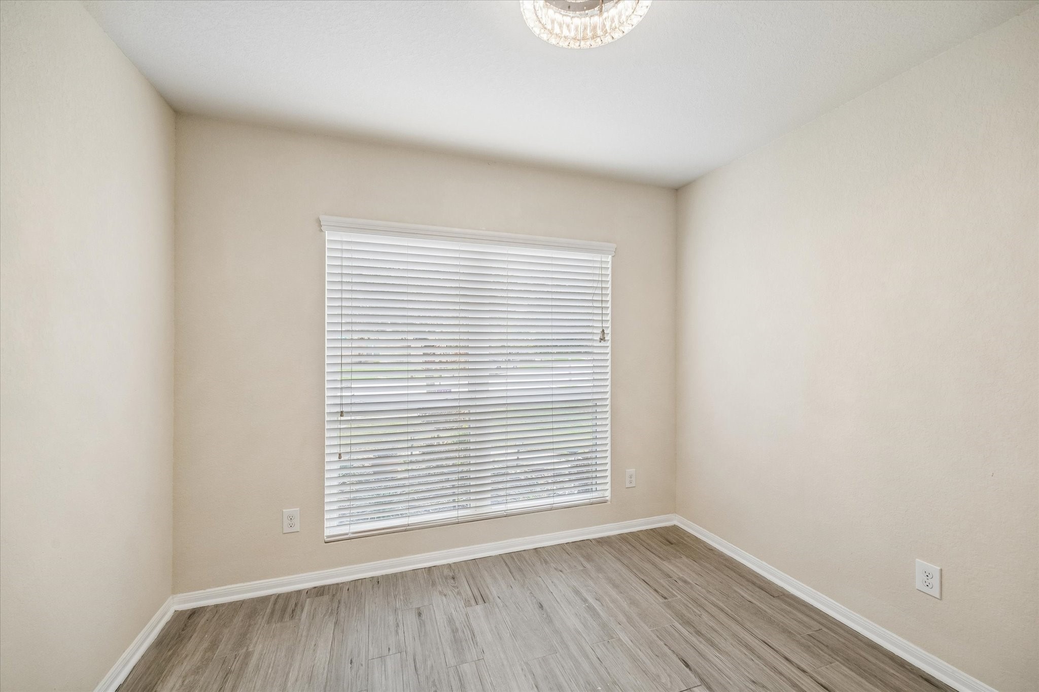 15642 South Fall Fern Circle Houston, TX 77044 - Photo 17 of 32 a view of an empty room with wooden floor and a window