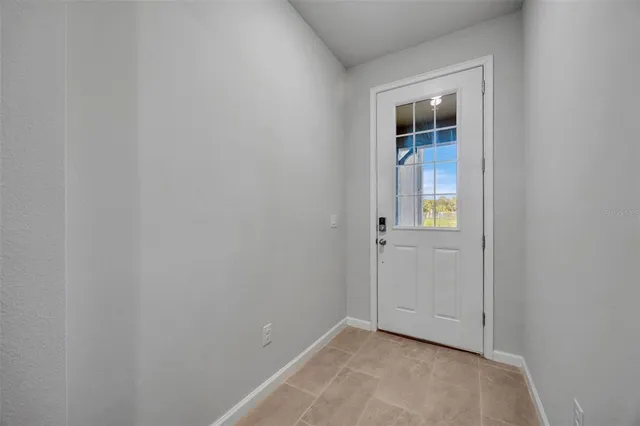 a kitchen with a refrigerator a stove a sink a dining table and chairs