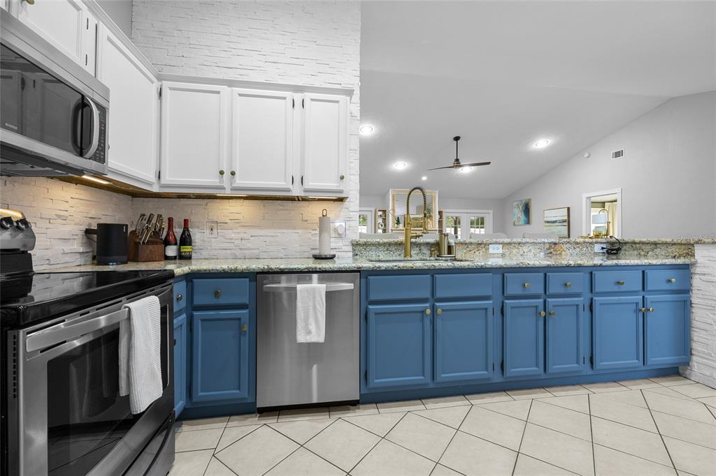 5628 Southwest 104 Terrace Gainesville, FL 32608 - Photo 12 of 31 a kitchen with stainless steel appliances granite countertop a sink stove and cabinets