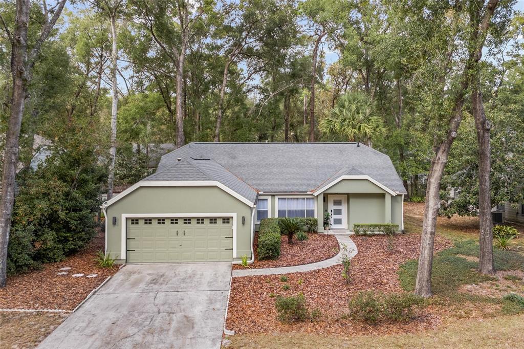 5628 Southwest 104 Terrace Gainesville, FL 32608 - Photo 26 of 31 a view of a house with a yard and large tree