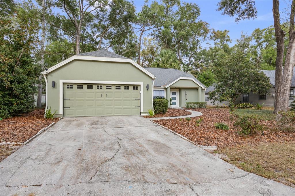 5628 Southwest 104 Terrace Gainesville, FL 32608 - Photo 28 of 31 a front view of a house with a yard and garage