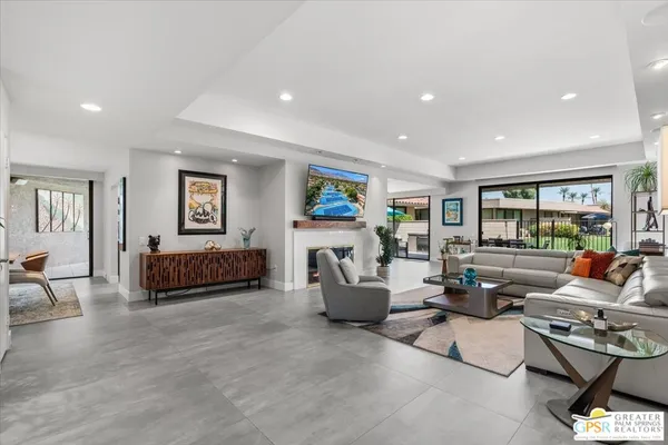 a kitchen with stainless steel appliances granite countertop a stove top oven a sink dishwasher a dining table and chairs with wooden floor