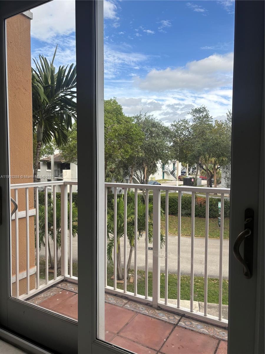 17710 Northwest 73rd Avenue, Unit 20220 Hialeah, FL 33015 - Photo 13 of 16 a view of a balcony with a floor to ceiling window wooden fence and floor