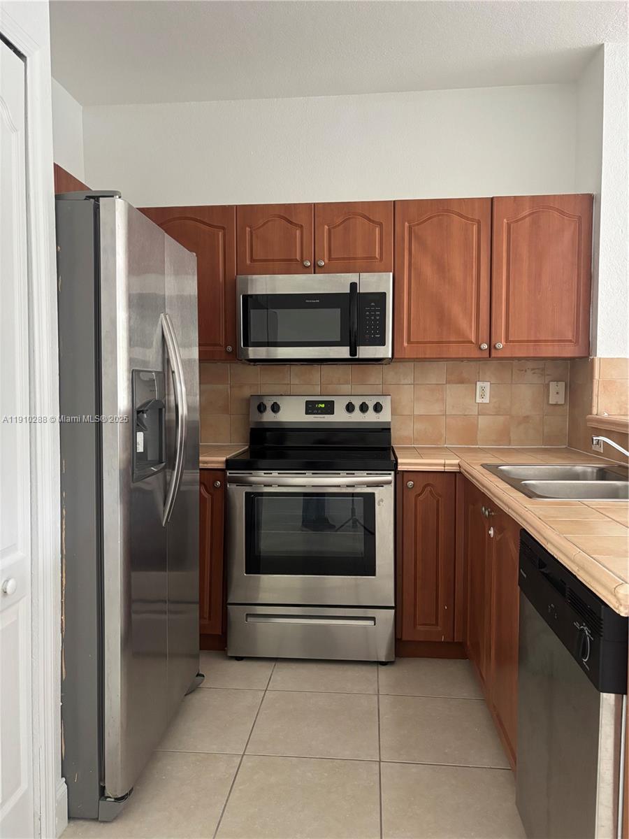 17710 Northwest 73rd Avenue, Unit 20220 Hialeah, FL 33015 - Photo 15 of 16 a kitchen with a sink and steel stainless steel appliances