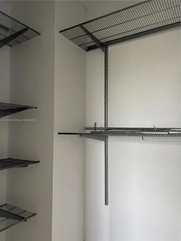a view of walk in closet with empty racks