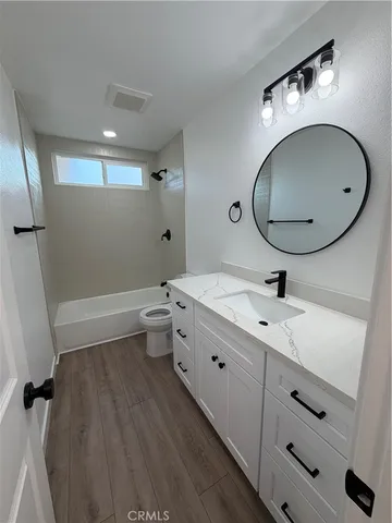 a bathroom with a double vanity sink mirror and toilet