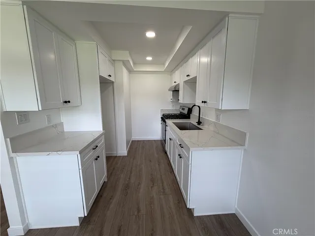 a kitchen with a sink a counter top space stainless steel appliances and cabinets