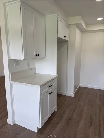 an empty room with wooden floor and cabinet
