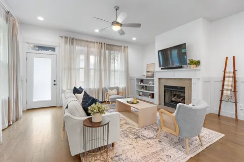 a living room with furniture a flat screen tv and a fireplace