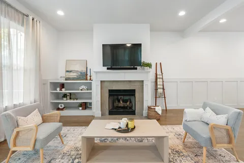 a living room with furniture a flat screen tv and a fireplace