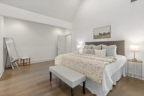 a bedroom with a bed a chair and a dresser