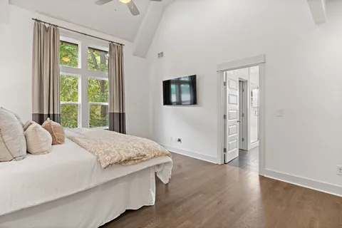 a bedroom with a bed and a flat tv screen on dresser