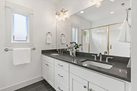a bathroom with double sink and a mirror