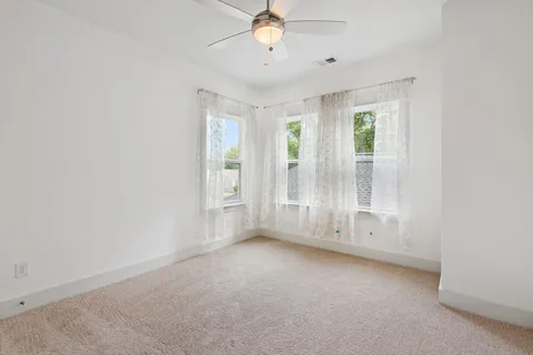 an empty room with windows and cabinet