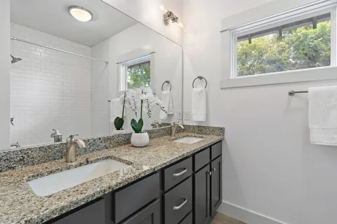 a bathroom with a granite countertop sink and a mirror