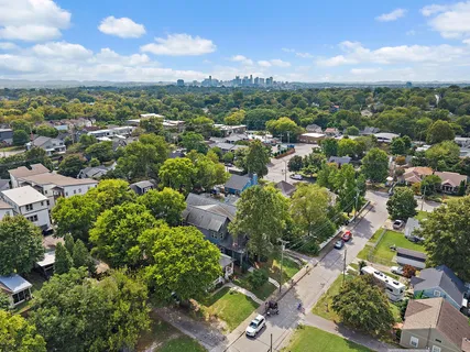an aerial view of residential houses with outdoor space and trees