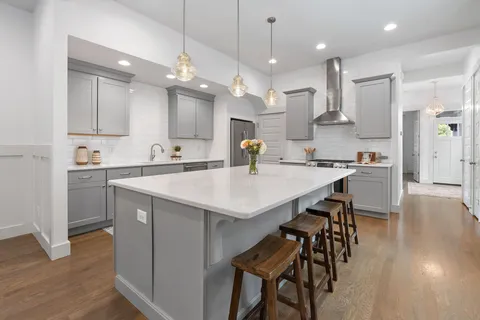 a kitchen with a dining table chairs sink and cabinets