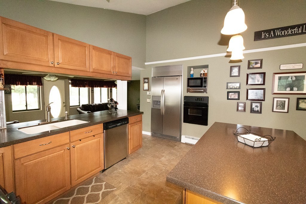 44 Flint Road Tyngsborough, MA 01879 - Photo 5 of 29 a kitchen with granite countertop a refrigerator a stove a sink dishwasher and white cabinets with wooden floor