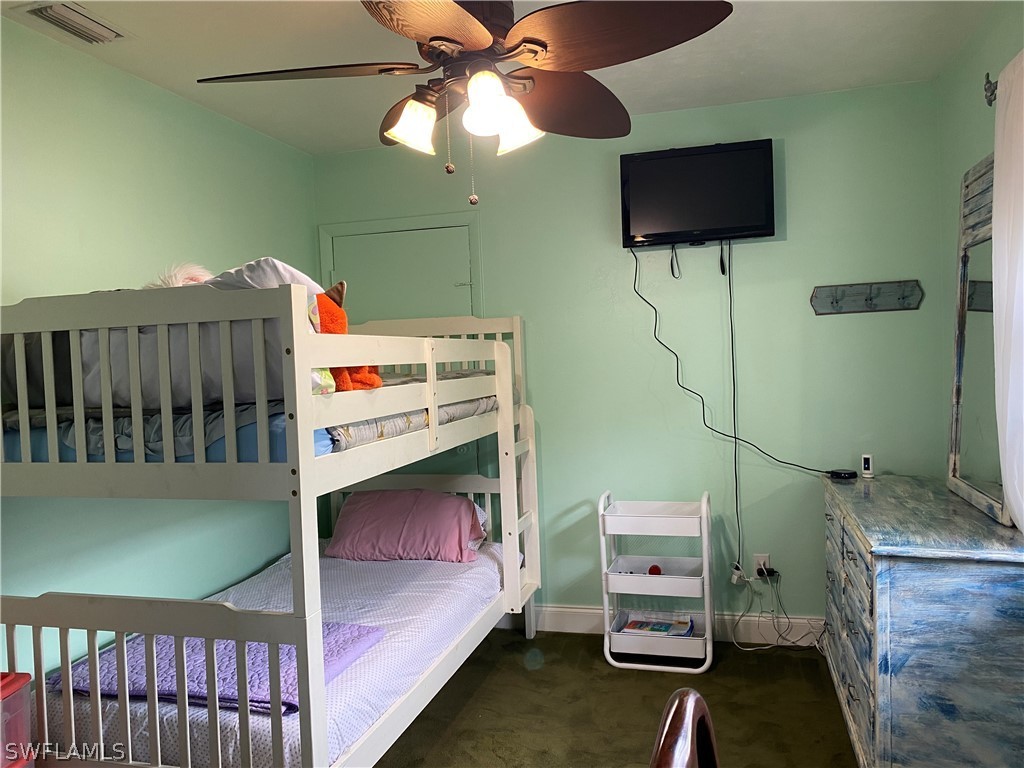 7334 Jonas Road Fort Myers, FL 33967 - Photo 19 of 29 a bedroom with a bed and flat screen tv