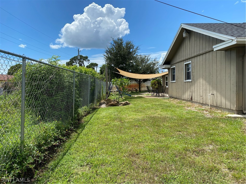 7334 Jonas Road Fort Myers, FL 33967 - Photo 3 of 29 a yellow house with flower garden in front of it