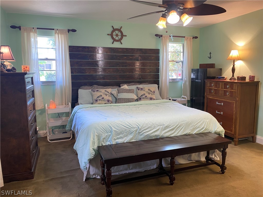 7334 Jonas Road Fort Myers, FL 33967 - Photo 8 of 29 a bedroom with a bed and a chandelier