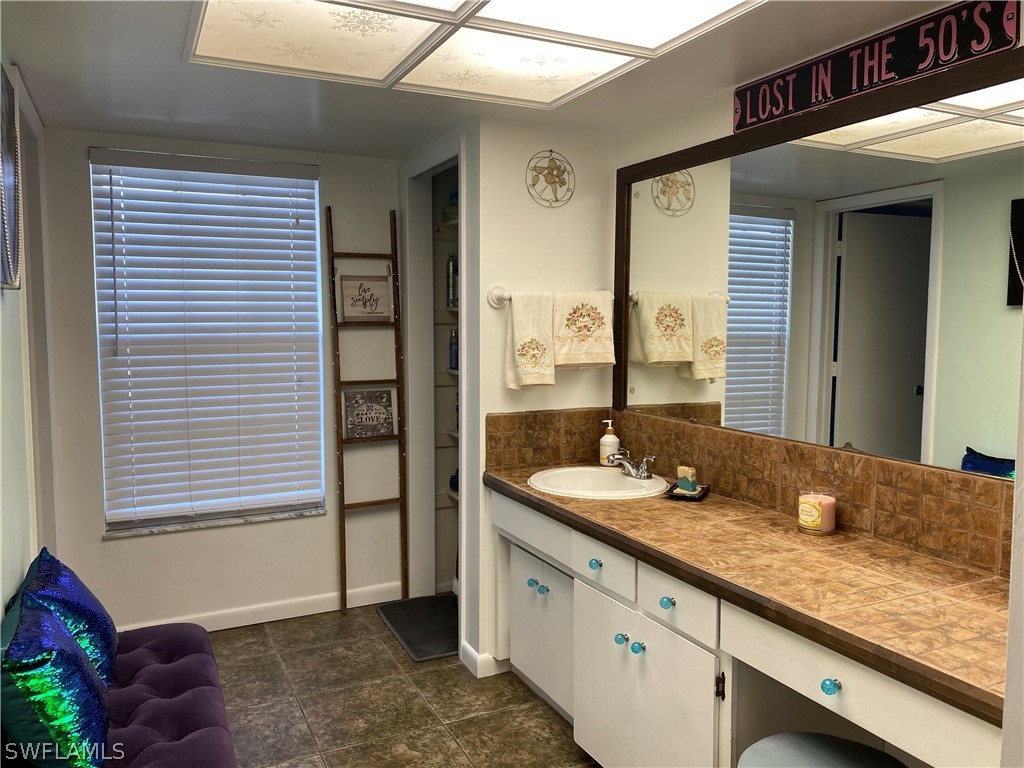 7334 Jonas Road Fort Myers, FL 33967 - Photo 9 of 29 a bathroom with a granite countertop sink and a mirror