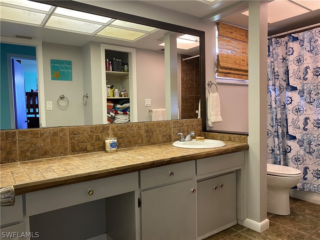 7334 Jonas Road Fort Myers, FL 33967 - Photo 10 of 29 a bathroom with a granite countertop sink a toilet and a mirror