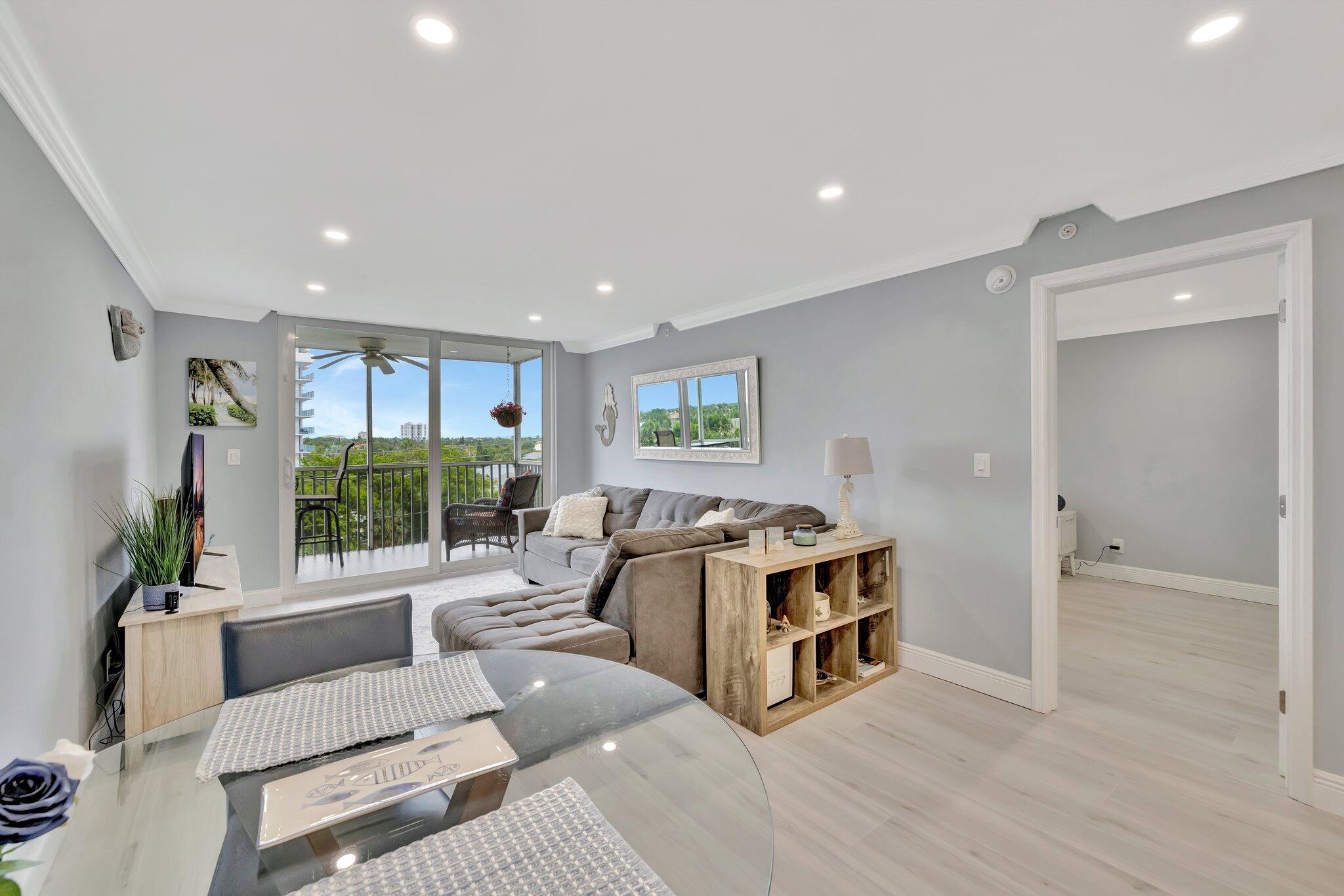 1505 North Riverside Drive, Unit 507 Pompano Beach, FL 33062 - Photo 16 of 39 a living room with a couch and a table with wooden floor