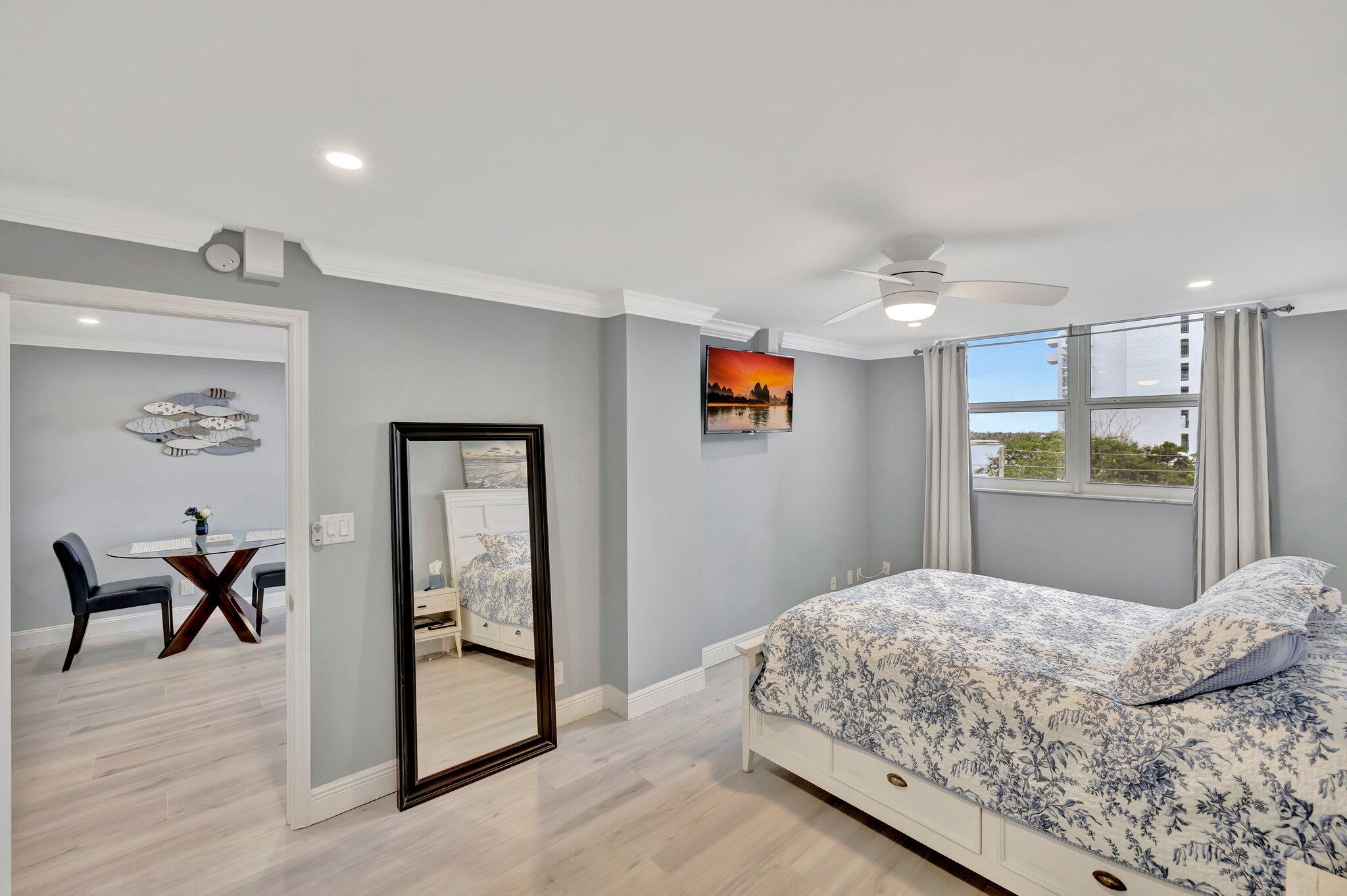 1505 North Riverside Drive, Unit 507 Pompano Beach, FL 33062 - Photo 21 of 39 a bedroom with a bed and a chandelier