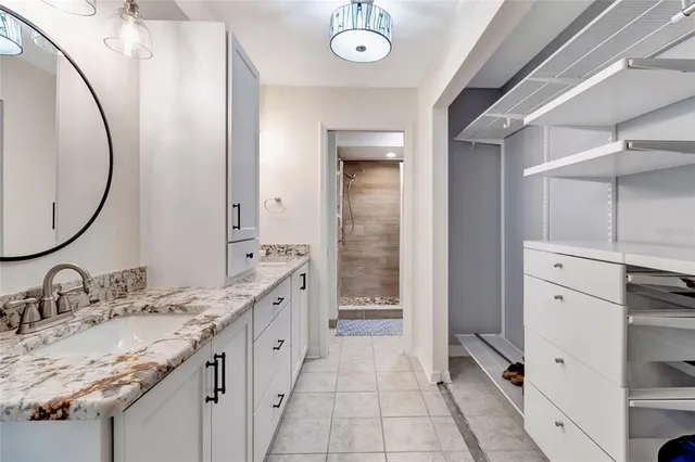 a spacious bathroom with a granite countertop double vanity sink and a mirror