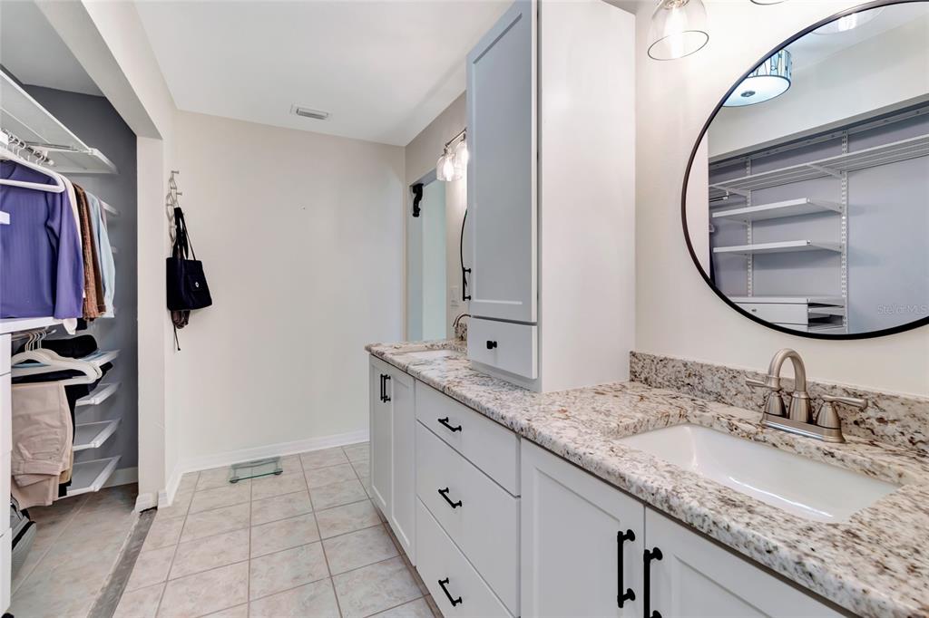 1908 Oak Circle Tavares, FL 32778 - Photo 16 of 28 a bathroom with a granite countertop sink and a mirror