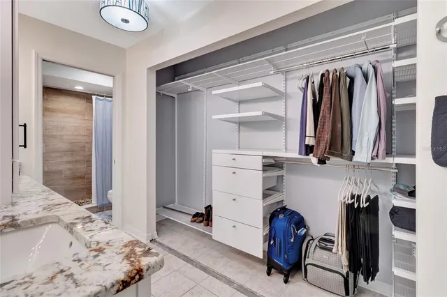 a view of walk in closet with clothes and shoes